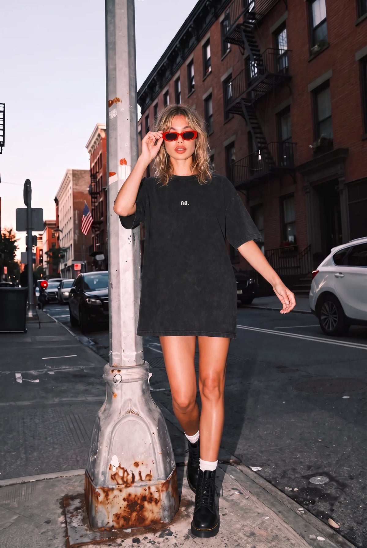 Woman wearing the black 'no.' oversized acid wash tee as a dress on a city street