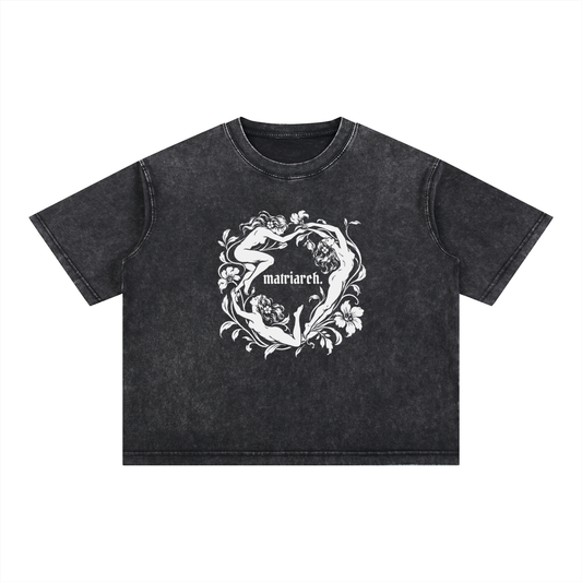 Black "matriarch." mineral wash boxy tee with three dancing women in a floral ring print